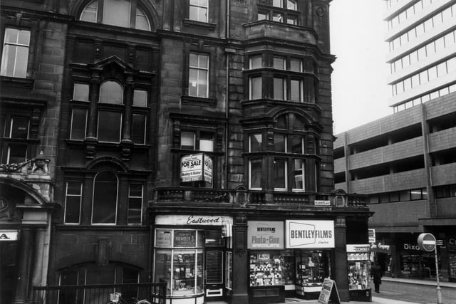 Albion Place with the YMCA building on the left. Eastwood tobacconists and Bentley Films Ltd. occupy shops on the ground floor. To the right is the junction with Albion Street and the tower block West Riding House.