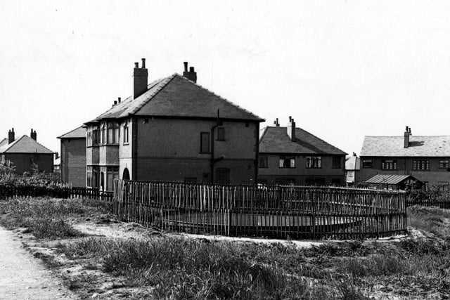 Circular static water supply tank next to semi detached houses on Cross Gates Lane in May 1943.