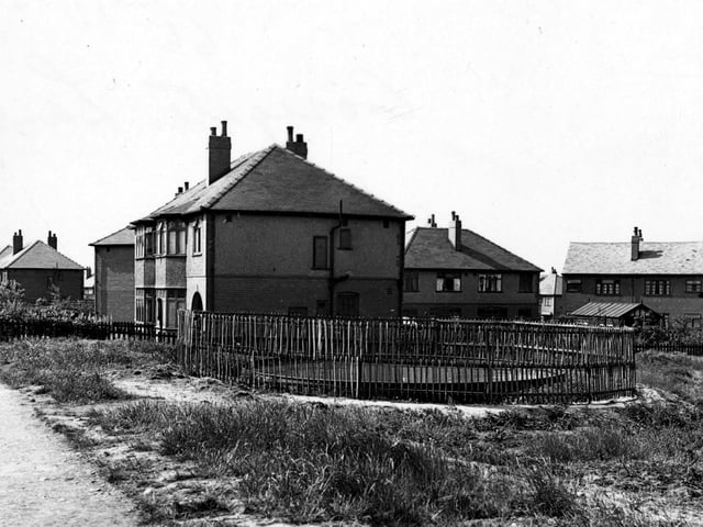 Circular static water supply tank next to semi detached houses on Cross Gates Lane in May 1943.