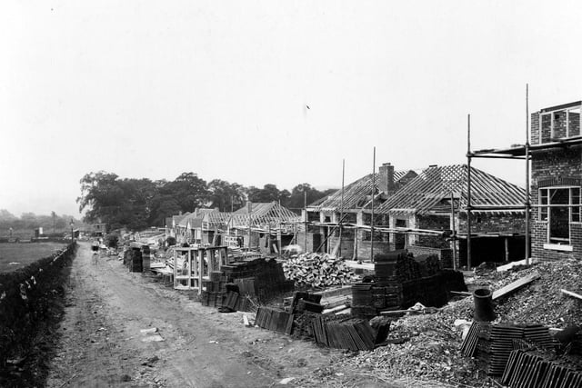 Construction of new houses on Vesper Lane,between Abbey Road and Vesper Road, August 1937. Bungalows are being built, roof timbers can be seen, slates, window frames, bricks and other materials are in view.