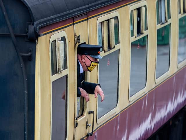 A guard wearing a face mask on the North Yorkshire Moors Railway
