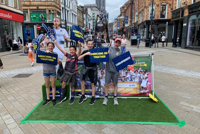 Fans hold up 'Marching on Together' banners on Briggate