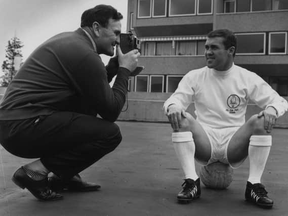 Leeds United manager Don Revie snaps a picture of Bobby Collins. (Getty)