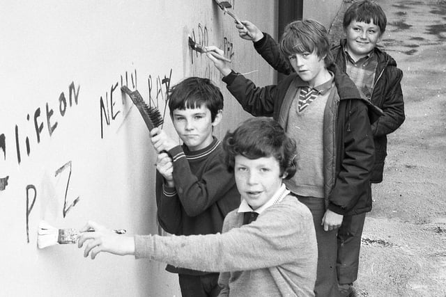 Robert Halshaw, 10;  Liam Donnelly, 12; Austin Taylor, 11; and Anthony Corrigan, 11 - all members of the "St Augustine's Youth Club Tidy Club" clean a wall in Manchester Road, Preston