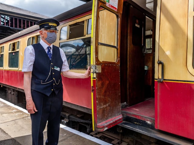 Station Foreman Peter Blake opening the carriage door