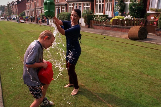 Carl Hackney, 11, gets a soaking from Eve Koziel-Donnelly, 11, whilst watering newly-laid turf on Methley Terrace.