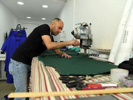 Syrian refugee tailor Jed Haji Rached volunteering to make scrubs for the NHS