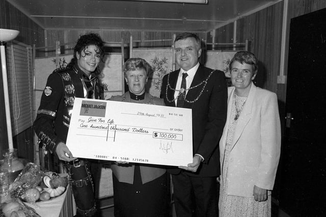 Michael Jackson handed over a cheque for charity to Leeds City Council officials while back stage.