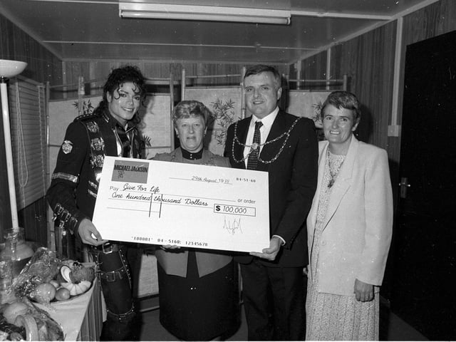Michael Jackson handed over a cheque for charity to Leeds City Council officials while back stage.