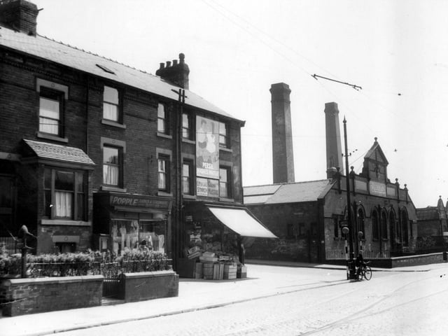 Shops and houses on corner of Compton Road and Hudson Road. Burton's clothing factory is on opposite corner. a boy with a bicycle stands at edge of road by two belisha beacons. Pictured in June 1939.