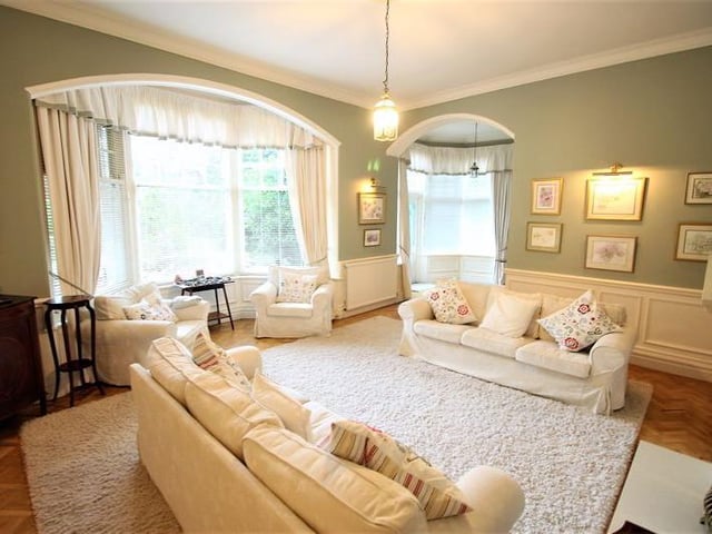 Generous lounge with large bay window and feature fireplace.