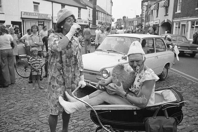It was the craziest, funniest pub crawl in the history of Garstang - a pram race frolic organised by the St Mary and Michael's Youth Club for the town's Youth Week. Pictured: Malcolm Williams "downs" his beer while "baby" John Wilding waits
