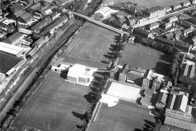 A view from August 1968 looking south west over buildings and fields. Fountain Street in the background, Wakefield-Bradford Railway Line on the left. Morley Grammar School which is surrounded by playing fields opened in July 1909.