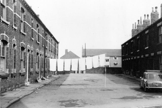 Commercial Square off Commercial Street in April 1967. Terraced houses with a line of washing across between the houses. A mini is parked to the right of the Square.