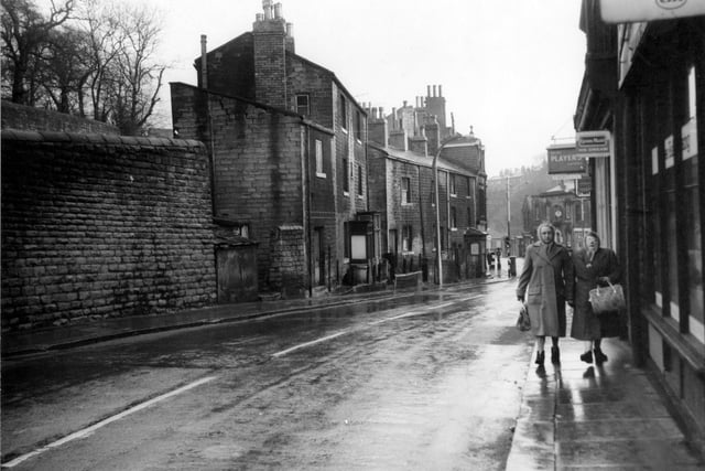 Brunswick Street in 1962. Fieldsend grocers shop on the right has hanging signs advertising Lyons cakes and Ice Cream as well as Players cigarettes. Two women with coats and bags are in the foreground.