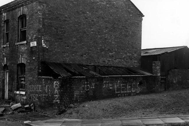 September 1974 and this photo shows a side view of no. 11 Powell Street, a derelict semi-detached house with graffiti covering the walls. This house was shortly to be demolished.