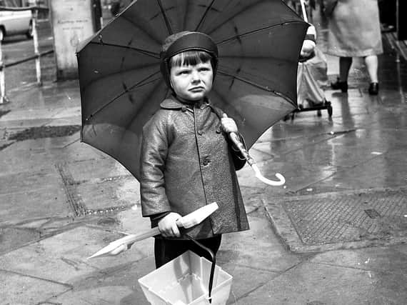 Flaming June turned into a damp and dreary month for Wiganers in 1972. This little boy pauses to check the weather at the top of Standishgate in Wigan town centre.