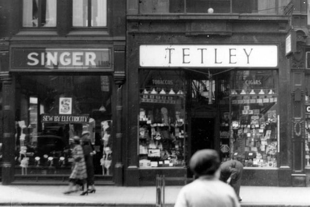 Shops on Boar Lane. In view are Singer Sewing Machines and Tetley Tobacconists.