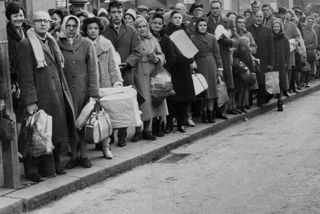 Christmas shoppers laden with the fruits of battle queue in Briggate for the bus home in December 1962.