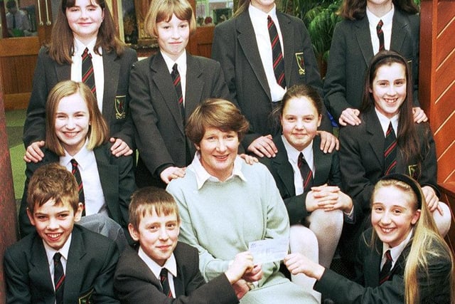 Caring pupils at St Edmund Arrowsmith RC High School handover the proceeds of fundraising to a representative from  Derian House children's hospice in 2006