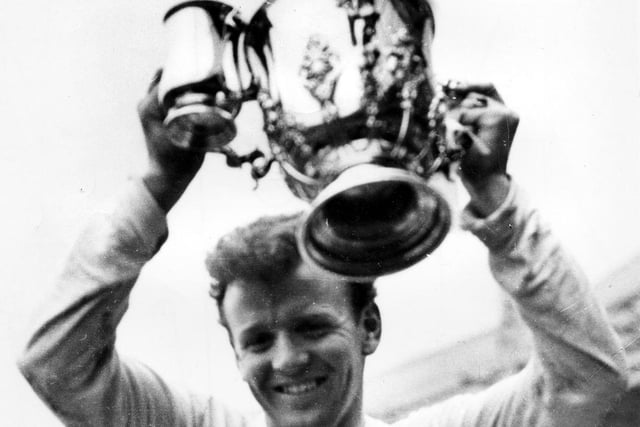 Captin Billy Bremner proudly holds aloft the League Cup trophy.