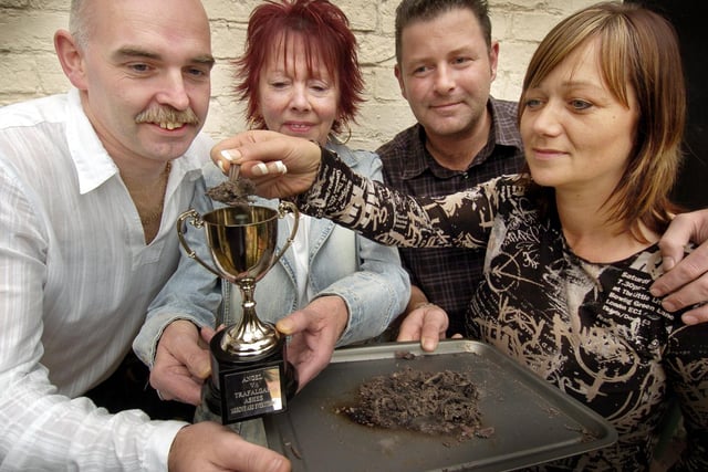 A beer soaked bar towel is burned to collect the Ashes for a trophy, for a twice yearly darts match. Staff from The Trafalgar and The Angel are pictured.