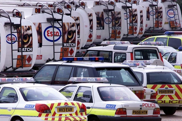 Police cars get ready to escort petrol tankers out of the oil refinery at Purfleet in Essex