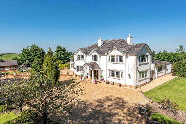 This stunning detached house has five bedrooms, a triple garage and stable block and is set within three acres.