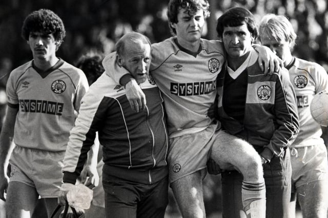 John Sheridan is helped off the pitch after breaking his leg against Barnsley at Oakwell in October 1983. Leeds won 2-0.