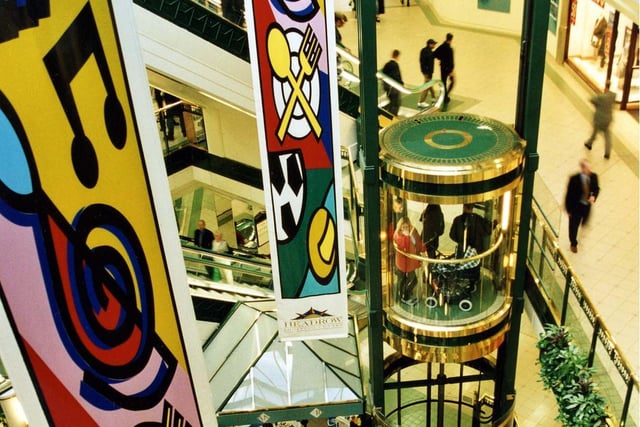The green and gold decorated glass lift which links the ground floor food court of the Headrow Shopping Centre to the first and second floors.