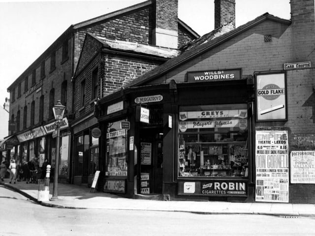 Corner of Town Street and Carr Crofts in May 1955. B. Murgatroyd tobacconists on the corner with advertisements for various tobaccos in the window and adverts for the Empire theatre on the wall.