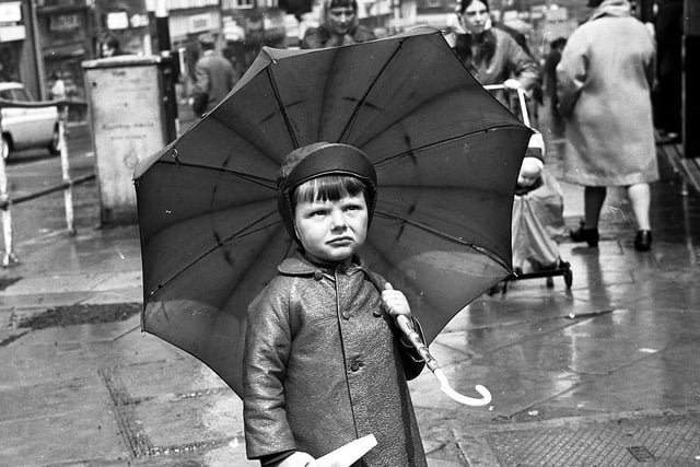 Flaming June turned into a damp and dreary month for Wiganers in 1972. This little boy pauses to check the weather at the top of Standishgate in Wigan town centre