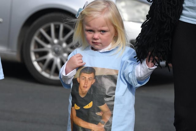 A little girl wearing a Kyle tshirt