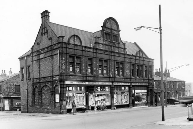 Leeds Industrial Co-operative Society is in view. Grocers and butchers departments can be seen, a delivery bicycle is leaning against the central window. To the left is Pembroke Street.