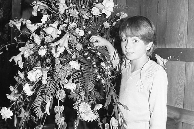 Slump-hit Blackpool was blooming again... thanks to a dazzling display of flower power. Crowds packed into the resort's Imperial Hotel to watch the pick of Britain's florists at work. Pictured is ten-year-old Lisa Shuck with one of the winning exhibits at the Interflora Florist of the Year contest