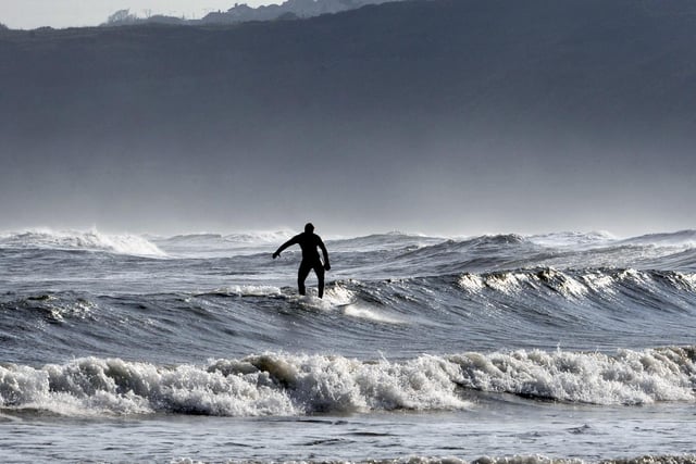 A surfer riding the waves in the South Bay.