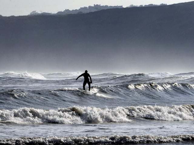 A surfer riding the waves in the South Bay.