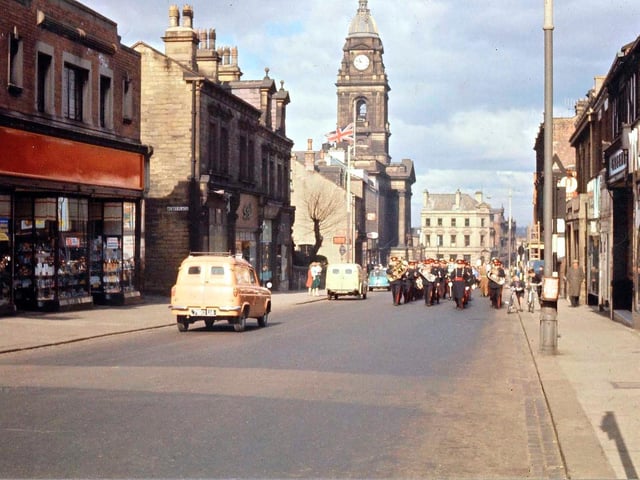 A procession can be seen marching along Queen Street with the Town Hall visible in the background. Note that the Town Hall flag is flying at half mast.
