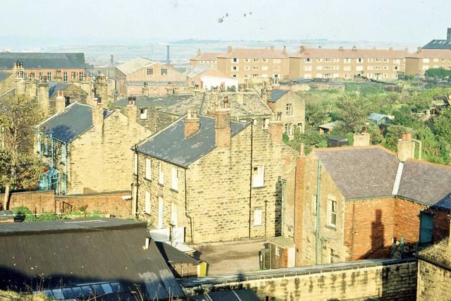The backs of houses in High Street are seen going diagonally across the photograph from the bottom right-hand corner to the top left. The photo was taken from the top of a spoil heap resulting from quarry workings.