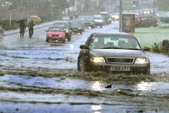 A motorist makes his way through flooded water on Meanwood Road after Leeds was hit by a snow storm.