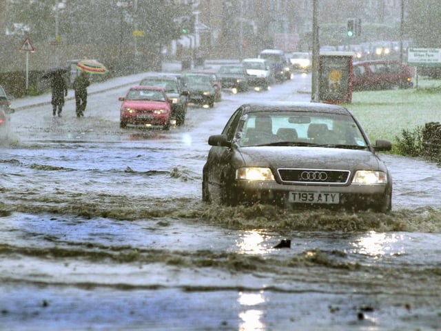 A motorist makes his way through flooded water on Meanwood Road after Leeds was hit by a snow storm.