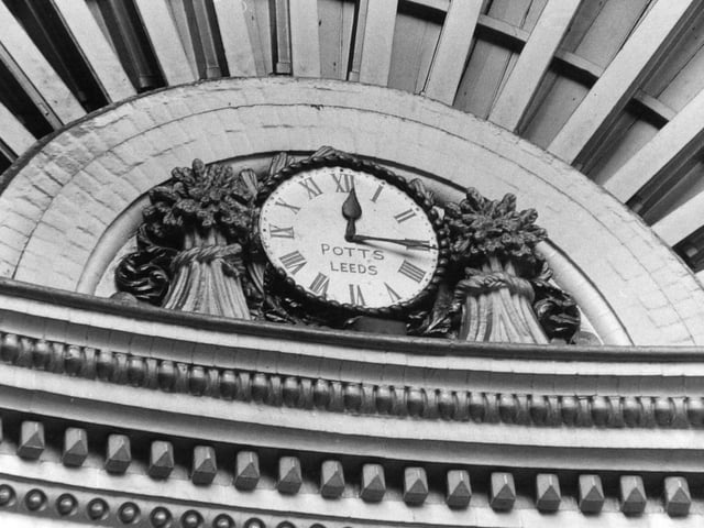 The clock is by William Potts and Sons of Leeds. It is flanked by sheaves of corn.