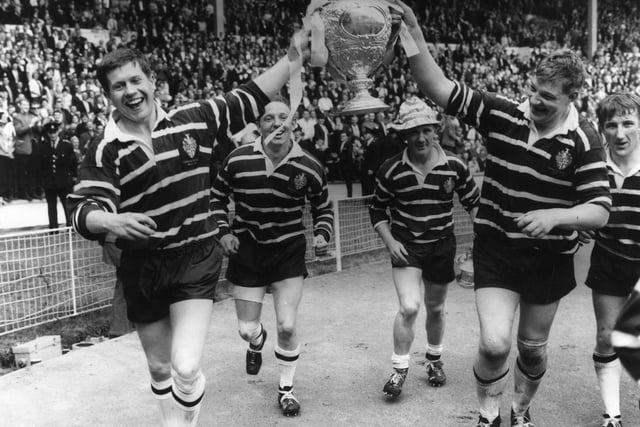Featherstone Rovers captain, Malcolm Dixon (right) holds the Rugby League Cup aloft with the help of a team mate after they had beaten Barrow at Wembley Stadium, London.