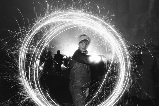 Dawn Wheatley puts a dash of sparkle into a wet Roundhay Park bonfire in November 1982.