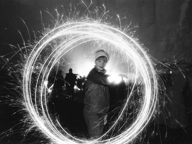 Dawn Wheatley puts a dash of sparkle into a wet Roundhay Park bonfire in November 1982.