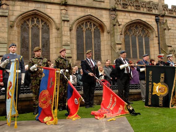 Standards are lowered during the service at Wigan Parish Church in 2010.