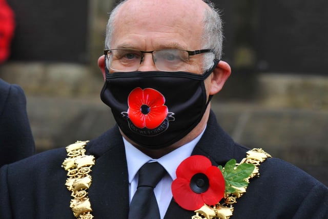 The Mayor of Wigan Coun Steve Dawber wearing a poppy face mask before laying a wreath at Wigan War Memorial.