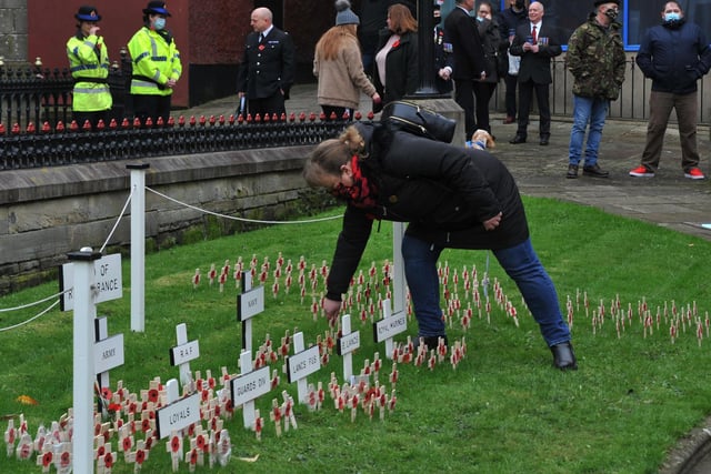 Members of the public place poppy crosses in the garden of remembrance at Wigan War Memorial.