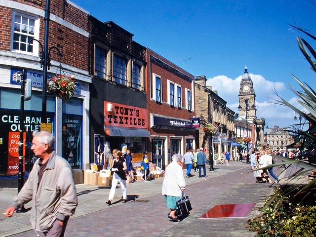 Queen Street towards the Town Hall from the end of Wesley Street. On the left is the row of shops that part of Wesley Street Mill was demolished for: originally Boots, Silver Library, Woolworths, Tony's Textiles and Yorkshire Bank.