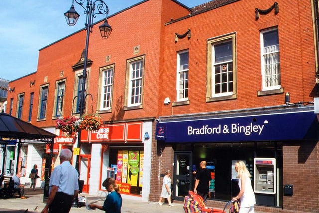 The 1938 Emporium of Morley Industrial Co-operative Society Ltd. on Queen Street has now been broken up into individual shops. Those visible in this picture include the Bradford and Bingley Building Society and Thomas Cook travel agents.